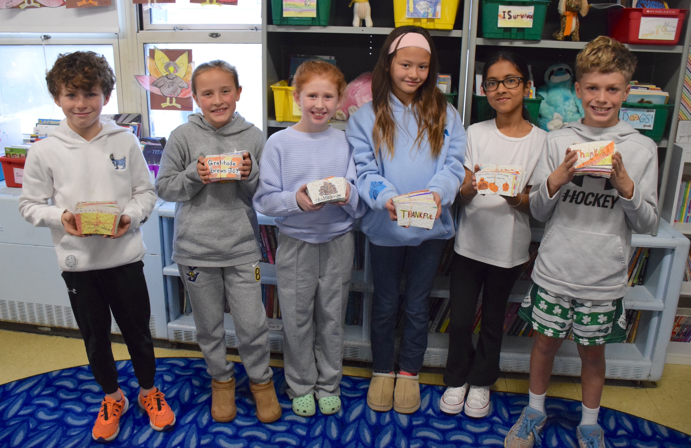six students holding coffee sleeves